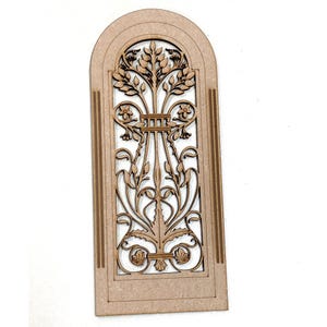 Puede incluir: Un recorte de madera de una puerta arqueada decorativa con intrincados diseños florales. El recorte está hecho de madera marrón claro y tiene una estética rústica y vintage.