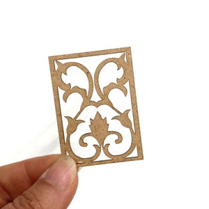 Op de afbeelding: Een bruin houten decoratief paneel met een uitgesneden ontwerp van een gestileerd bloemenpatroon.