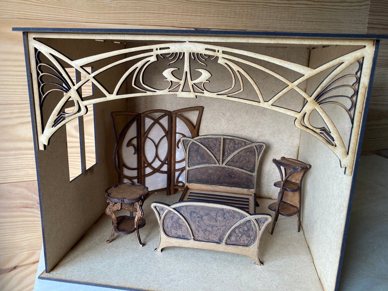 May include: A miniature dollhouse room with a wooden bed, two side tables, a screen, and a decorative archway. The room is made of wood and has a light brown finish.