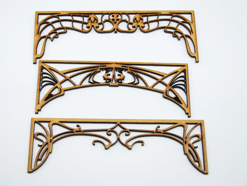 May include: Three wooden decorative arches with intricate Art Nouveau designs. The arches are made of light brown wood and have a delicate, intricate pattern.