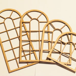 May include: Four unfinished wooden arched window frames with a grid pattern. The frames are different sizes and are arranged in a staggered pattern.