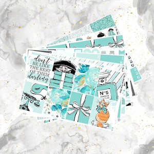May include: A set of planner stickers featuring a turquoise and white color scheme. The stickers include a woman wearing a hat and holding a gift box, a perfume bottle, a cat wearing a bow tie, and a quote that says "don't be like the rest of them darling".