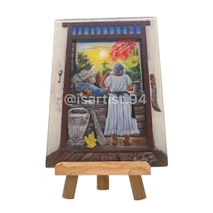 May include: A framed painting depicting two figures in a doorway, with a vibrant sunset visible through the opening. The artwork includes a key, a mortar, and a machete. The painting is displayed on a small wooden easel.