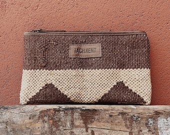 May include: A brown and beige woven clutch with a leather patch that says "TASHKENT".