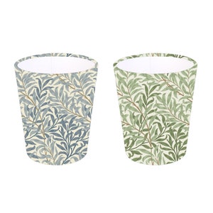 May include: Two ceramic cups with a floral pattern. The cup on the left has a blue and green floral pattern. The cup on the right has a green and brown floral pattern.