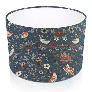 Pode incluir: Abajur cil&iacute;ndrico com fundo azul com um padr&atilde;o repetido de p&aacute;ssaros, flores e folhagens em vermelho, branco e cinza. O interior do abajur &eacute; branco.