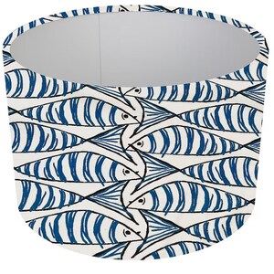 May include: A white lampshade with a blue and black fish pattern. The fish are stylised and have a repeating pattern.