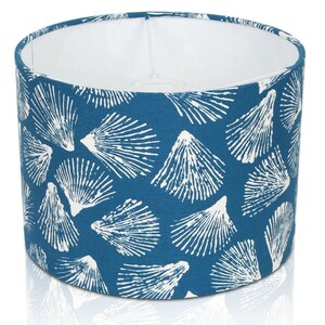 May include: A blue lampshade with a white seashell pattern.