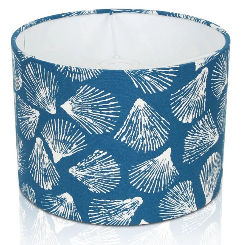 May include: A blue lampshade with a white seashell pattern.