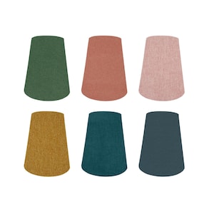 May include: A set of six tapered drum lamp shades arranged in two rows of three. The shades feature a textured fabric finish in solid colours including dark green, terracotta, light pink, mustard yellow, teal, and dark blue-grey.