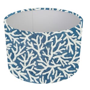 May include: A blue lampshade with a white coral pattern. The lampshade is cylindrical and has a white interior.