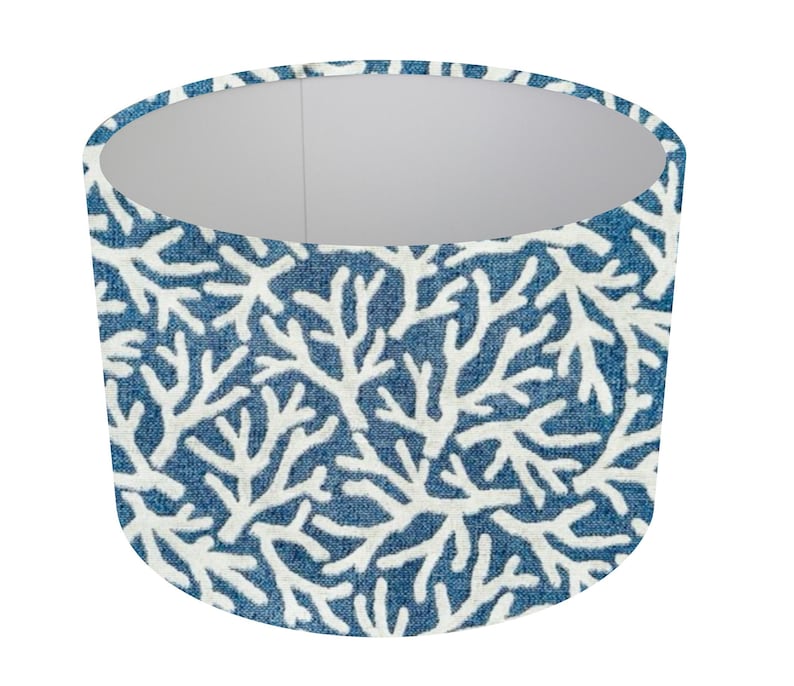 May include: A blue lampshade with a white coral pattern. The lampshade is cylindrical and has a white interior.