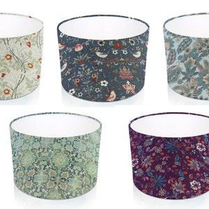 Pode incluir: Cinco abajures cil&iacute;ndricos com padr&otilde;es florais. Os abajures apresentam designs em v&aacute;rias cores, incluindo verde, azul e roxo. Cada abajur tem um interior branco e um exterior estampado, mostrando motivos bot&acirc;nicos e decorativos.