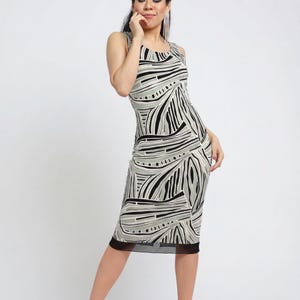 May include: Sleeveless knee-length dress with a black, white, and olive green abstract pattern. The dress has a black mesh hem and is paired with light pink sandals. The dress is form-fitting and suitable for various occasions.