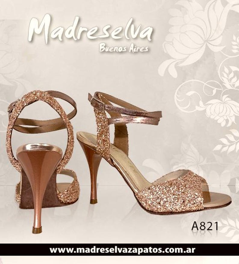 May include: A pair of rose gold glitter high-heeled sandals with ankle straps and a metallic finish on the heel. The text Madreselva Buenos Aires and A821 are visible. The website www.madreselvazapatos.com.ar is printed at the bottom of the image.