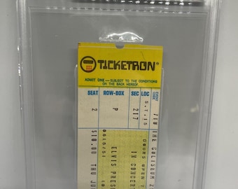 May include: A graded Ticketron concert ticket stub for an Elvis Presley performance at the Richfield Coliseum on July 10, 1975. The yellow and white ticket is encased in a clear protective plastic holder with a label indicating a grade of 5 EX.