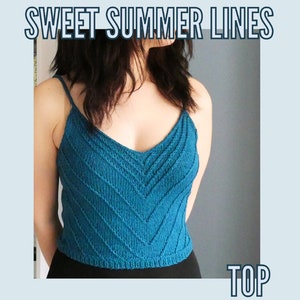 Op de afbeelding: Een tealblauw gebreid tanktop met een v-hals en een chevron-patroon. Het topje is gecropped en heeft dunne bandjes. De tekst "SWEET SUMMER LINES TOP" is zichtbaar boven het topje.