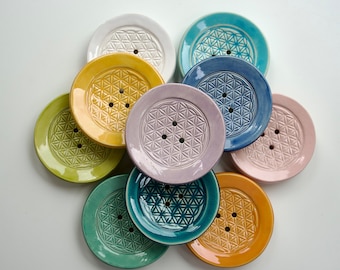 Petit porte-savon rond de 7 cm de diamètre, disponible en plusieurs couleurs, en céramique avec trous de drainage.