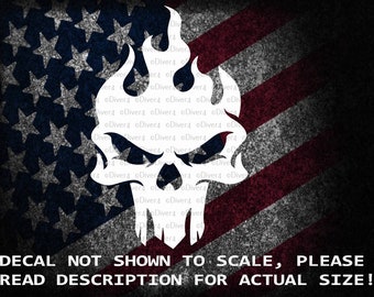 May include: White skull with flames on a red, white and blue American flag background. The text "DECAL NOT SHOWN TO SCALE, PLEASE READ DESCRIPTION FOR ACTUAL SIZE!" is at the bottom of the image.