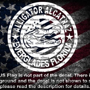 Peut inclure: Un autocollant circulaire avec un alligator dans un cercle blanc, avec les mots "ALLIGATOR ALCATRAZ EVERGLADES FLORIDA" en cercle. Le fond est un drapeau américain vieilli. Le texte en bas indique que le drapeau américain ne fait pas partie de l'autocollant.