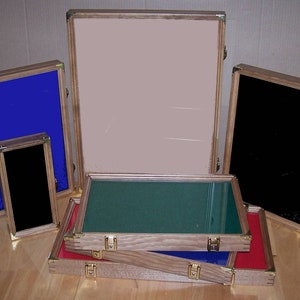 May include: Assortment of wooden display cases with glass lids. The cases are in various sizes and colors, including blue, green, black, and red.