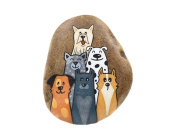 May include: A painted rock with five dogs on it. The dogs are all different breeds and colors. The rock is brown and has a rough texture.