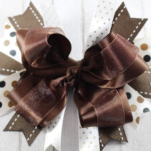 May include: A brown satin ribbon bow with white and brown polka dot ribbon accents.