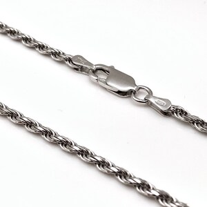 May include: A silver rope chain necklace with a lobster clasp.