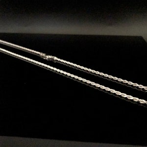 May include: A silver rope chain necklace. The chain is made of a twisted rope design.
