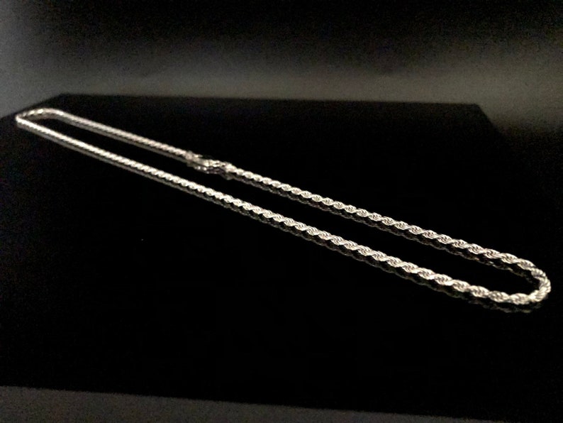 May include: A silver rope chain necklace. The chain is made of a twisted rope design.