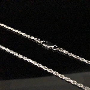 May include: A silver rope chain necklace with a lobster clasp.