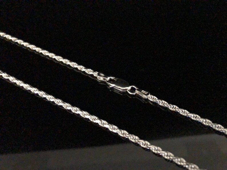 May include: A silver rope chain necklace with a lobster clasp.
