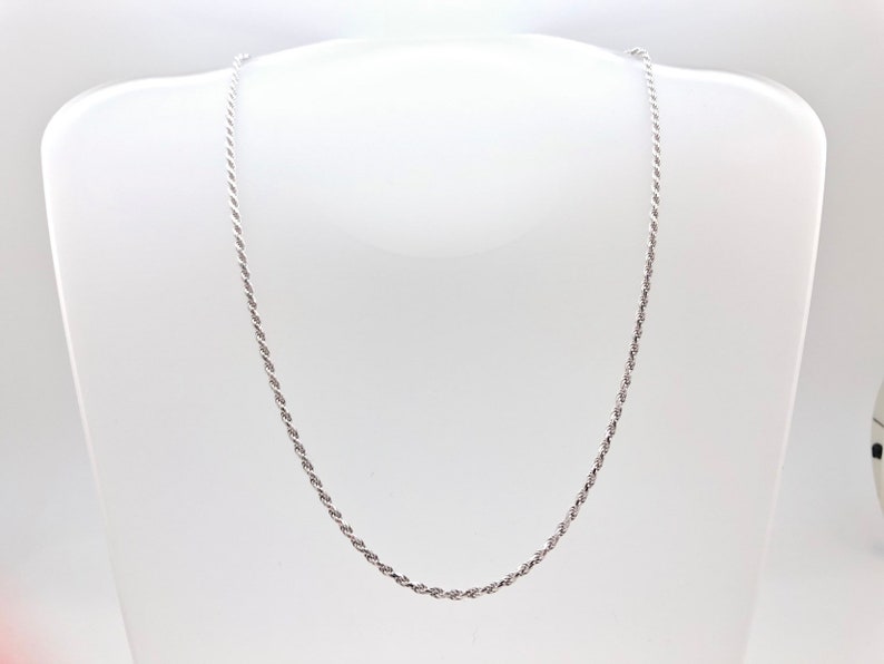 May include: A silver rope chain necklace. The chain is made of a twisted rope design.