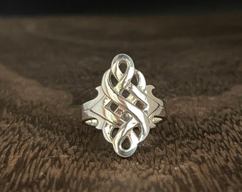 May include: A silver ring with a knot design. The ring is made of a smooth, polished metal and has a delicate, intricate design.