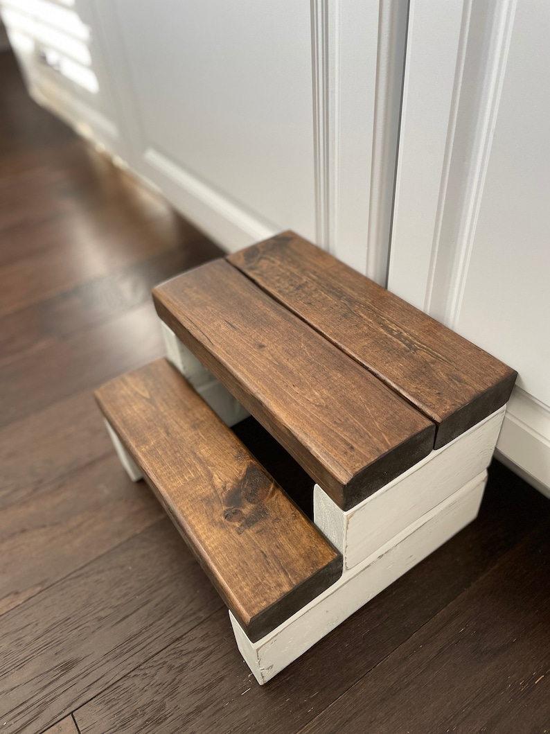 Wooden step stool, dark walnut stained steps with rustic white painted supports, personalized name hand painted on step, step stool in a kitchen, step stool against cabinet, kids step stool, adult weight