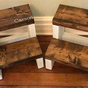 Two large wooden step stool, dark walnut stained steps with rustic white painted supports, personalized name hand painted on step, step stool in a kitchen, step stool against cabinet, kids step stool, modern style