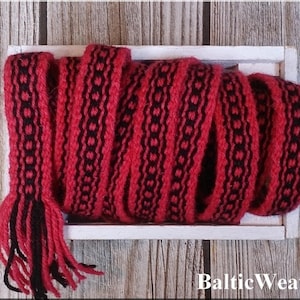 Op de afbeelding: Rode en zwarte geweven trim met een geometrisch patroon. De trim zit in een houten doos met de tekst "Baltic Weaver" op de bodem.