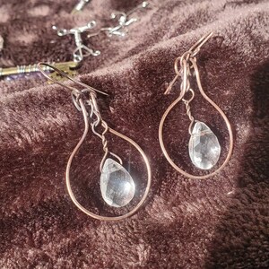 Copper wire wrapped circle earrings with clear faceted teardrop bead in center