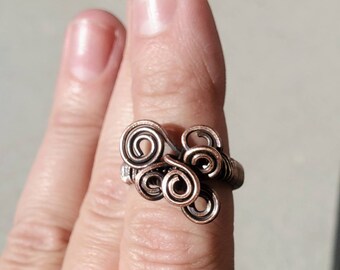 Wire wrapped antique copper ring with hand shaped swirls