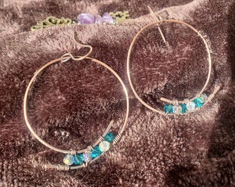 Antique finished copper hoop wire wrapped with small green and clear faceted crystal beads dangling from hand shaped copper ear wire