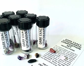May include: A collection of small glass vials with black caps, each labeled "DARK EXACT LITHOMANTIC COMPOSITION SET." The vials contain various gemstones. A printed instruction card is also present, with text about creative writing.