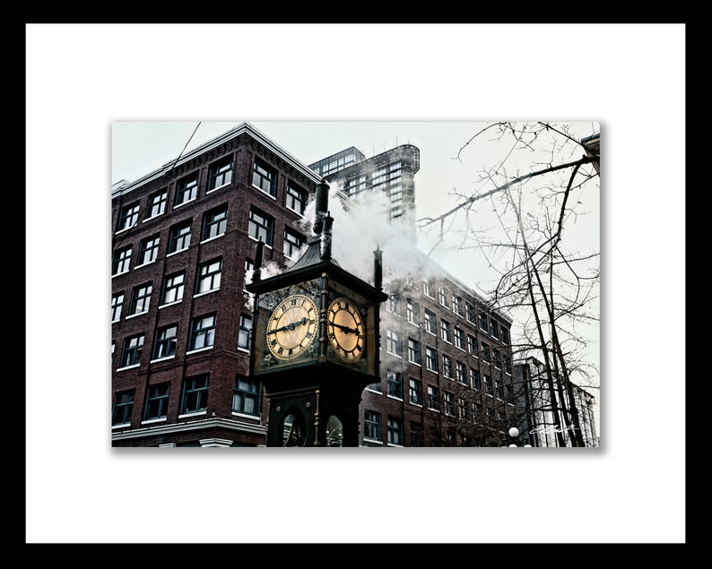 May include: A vintage clock tower with a gold face and black hands, emitting steam from the top, in front of a brick building with a cloudy sky in the background.