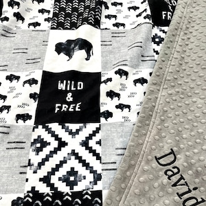 May include: Black and white baby blanket with a buffalo pattern, geometric designs, and the words "Wild & Free". The blanket is personalized with the name "David" in gray embroidery.