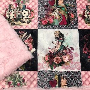 May include: A pink and black patchwork fabric with a quilted design. The fabric features images from Alice in Wonderland, including the Queen of Hearts, Alice, and the Mad Hatter.
