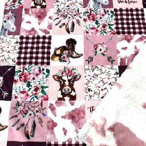 May include: A pink and brown patchwork quilt with a cow, horse, and floral designs. The quilt has a quote that reads "Though she be but little, she is fierce".