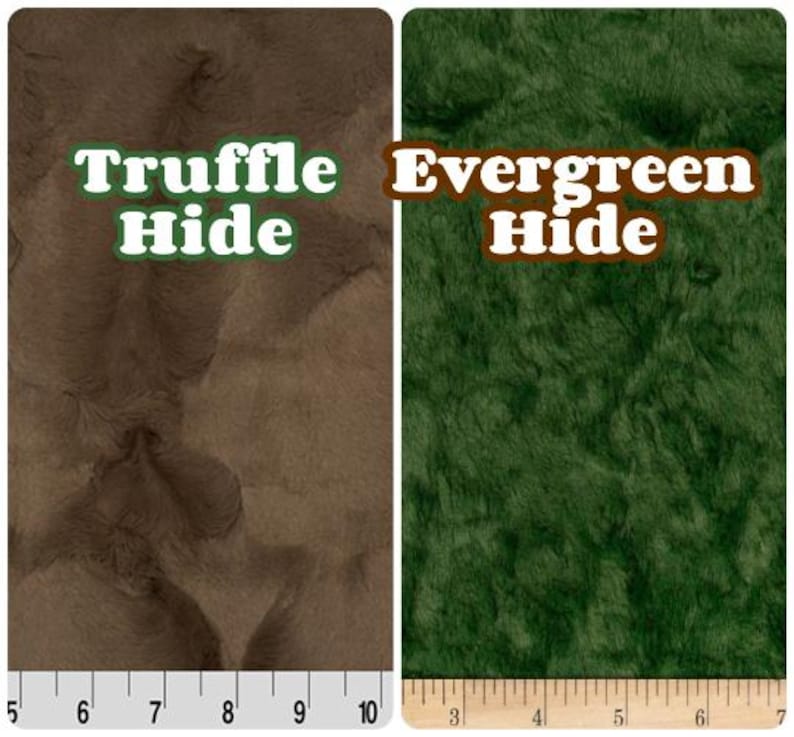 Może przedstawiać: Dwie pr&oacute;bki tkanin, jedna brązowa i jedna zielona, o teksturowanym, futrzanym wyglądzie. Brązowa pr&oacute;bka jest oznaczona jako "Truffle Hide", a zielona jako "Evergreen Hide". Linijki znajdują się wzdłuż dolnej części każdej pr&oacute;bki.