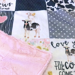 May include: A pink and white patchwork baby blanket with a cow, lamb, and chick design. The blanket has the text "Love you till the cows come home" and "Love you till the cows come home".
