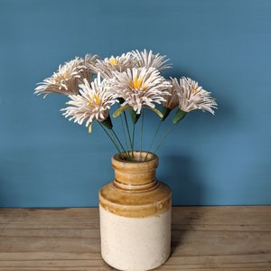 table display consisting od white daisies in a vintage vase