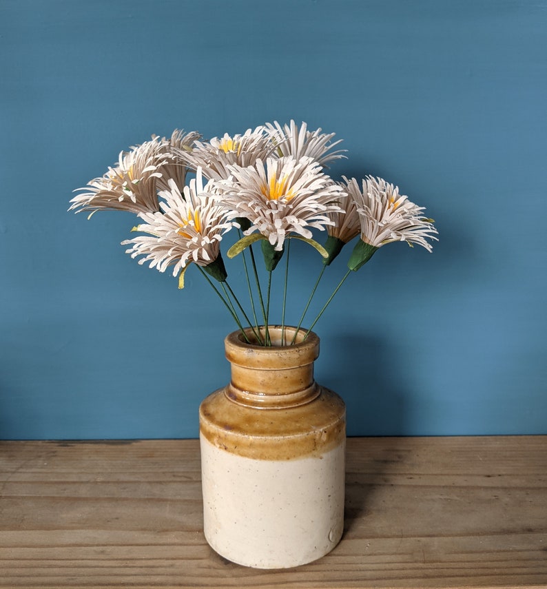 table display consisting od white daisies in a vintage vase