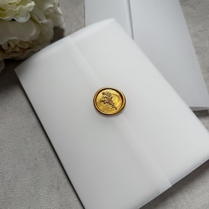 May include: White envelopes sealed with a gold wax stamp. The stamp features a detailed design. The envelopes are stacked, with one partially open, revealing the interior. The background is a neutral gray.